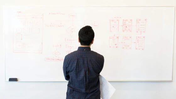 man looking at board and crafting a plan to his business