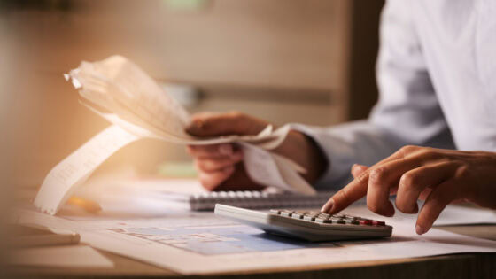 close up of business accountant using calculator while working i